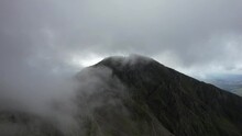 Big Mountains In The Clouds. Lake District By Drone In 4K. Scafell Pike, Highest Mountain In England. Drone Flying Through Clouds, Dramatic Reveal Of Climbers And Hikers. Group Of People On Summit.