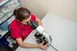 © andyborodaty - Beautiful scientist looking under microscope. Female scientist using a microscope in a chemical laboratory.