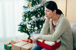 © PR Image Factory - chinese female sitting in sulky silence with a box is unhappy with the cheap Christmas present she got. asian girl is looking away in anger for her boyfriend didn’t spend time with her on the holiday