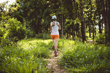 Trail Runner Running In Summer Forest Trail