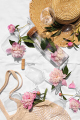 Poster - Flat lay composition with beautiful peonies and wineglasses on white fabric