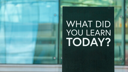 What did you learn today? on a sign outside a modern glass office building	