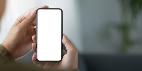 mockup image blank white screen cell phone.women hand holding texting using mobile on sofa