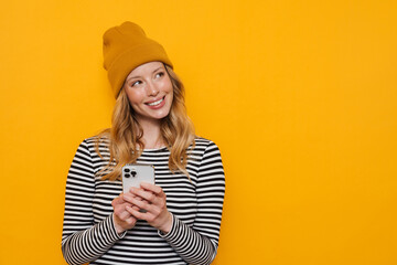 Poster - Young blonde woman wearing hat smiling and using cellphone