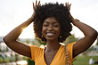 © fotofabrika - Portrait of a young african american woman smiling standing at the city.