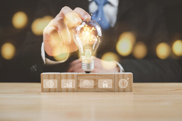 Businessman's hand resting on a lamp Wood Block, Search, Ideas, Business Icon Demonstrate business planning ideas, investments, currency, banks, digital asset sales, stocks, funds to success, concepts