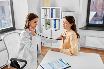 medicine, healthcare and people concept - female doctor with stethoscope and woman patient at hospital