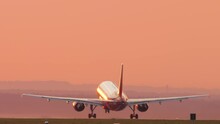 Cinematic Footage Of A Jet Plane Taking Off And Climbing Into The Sunset. Picturesque Sunset And Flying Away Airliner. Tourism And Travel Concept, Modern Aviation