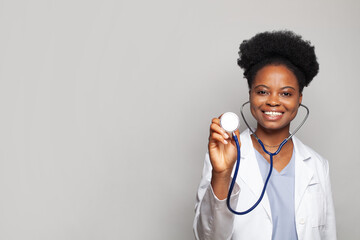 Wall Mural - Beautiful female medical worker, doctor or practitioner with stethoscope against white studio wall banner background