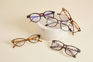 Wall Mural - fashion eyeglass frames, glasses on ceramic podium, creative presentation of eyeglasses