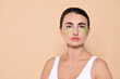 © New Africa - Beautiful woman with under eye patches on beige background. Space for text
