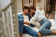 Leinwandbild Motiv Young attractive couple lying in the bed having fun in cozy boho orangery