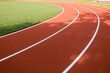 © vejaa - School sports stadium with red artificial rubber ground running tracks white lines on it