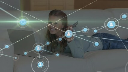Poster - Animation of network of connections with icons over caucasian woman using laptop