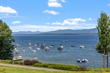 Wall Mural - Aerial view of floating boat in lake Winnipesaukee in background of mountains