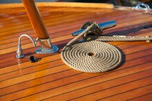 Rope Neatly Coiled On The Wooden Deck Of A Boat