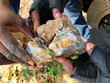 Ghanaian policemen observe some ore seized on pits operated by artisanal gold miners to verify the presence of visible gold. In Ghana, artisanal mining is called 