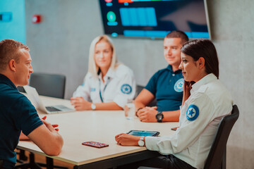 Wall Mural - Group of security guards sitting and having briefing In the system control room They're working in security data center surrounded by multiple Screens