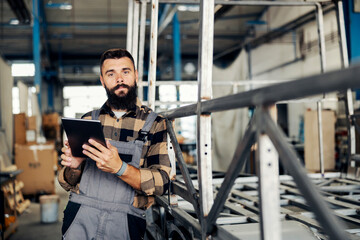 Wall Mural - An industry worker checking on bus construction in vehicle production factory.