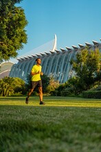Hispanic Handsome Man Jogging In The Garden Of The City Of Arts And Sciences Park, Valencia, Spain.