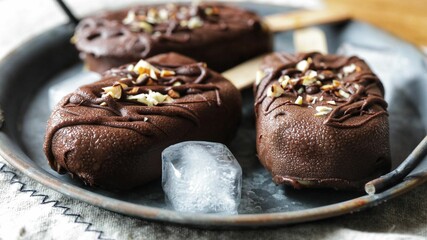 Poster - Few delicious homemade vegan ice cream bars covered with chocolate and nuts on a silver plate