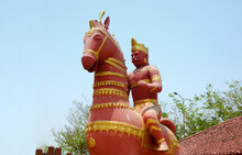  Man Riding A Horse Terracotta Statuette Against Blue Sky In Public Park