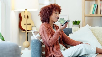 Wall Mural - Talking on phone call, communicating with voice notes while relaxing on the couch in home living room on weekend. Smiling, happy and expressive woman with afro sharing gossip, news and story on tech