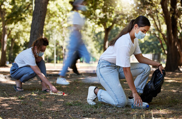 Cleaning park, community service and volunteer workers helping pick up trash and plastic bottles in care of environment. Support team of casual activists recycling, working together to end pollution