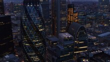 Aerial Tilting Shot Of The London Business District. 30 St Mary Axe Aka The Gherkin In The Foreground And The Salesforce Tower In The Background At Dusk
