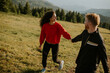 © BGStock72 - Smiling couple walking with backpacks over green hills