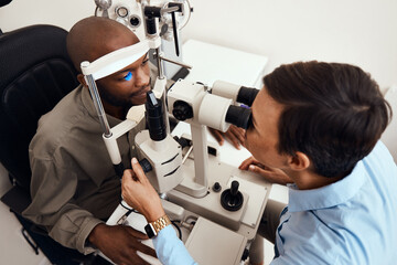 Eye, vision or sight test or exam of a patient above at an optometrist, optician or ophthalmologist. Testing and checking eyesight on a ophthalmoscope for optical glasses or contact lenses at clinic.