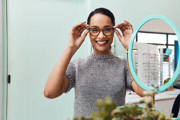 Wall Mural - Woman wearing pair of trendy glasses, stylish spectacles and new prescription lenses at an optometrist. Portrait of a customer choosing, buying and shopping for frames for better vision and eyesight