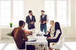 © Studio Romantic - Diverse group of serious young employees having corporate meeting, sitting around office table with modern laptop computer, discussing business strategy and listening to team leader making suggestion