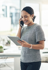 Wall Mural - Professional smiling businesswoman talking on phone call with client in modern office. Young design employee working on appointment booking on tablet standing in casual startup company