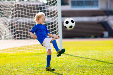 Kids play football. Child at soccer field.