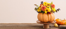 Beautiful Autumn Bouquet In Pumpkin On Table Against Light Background. Banner For Design