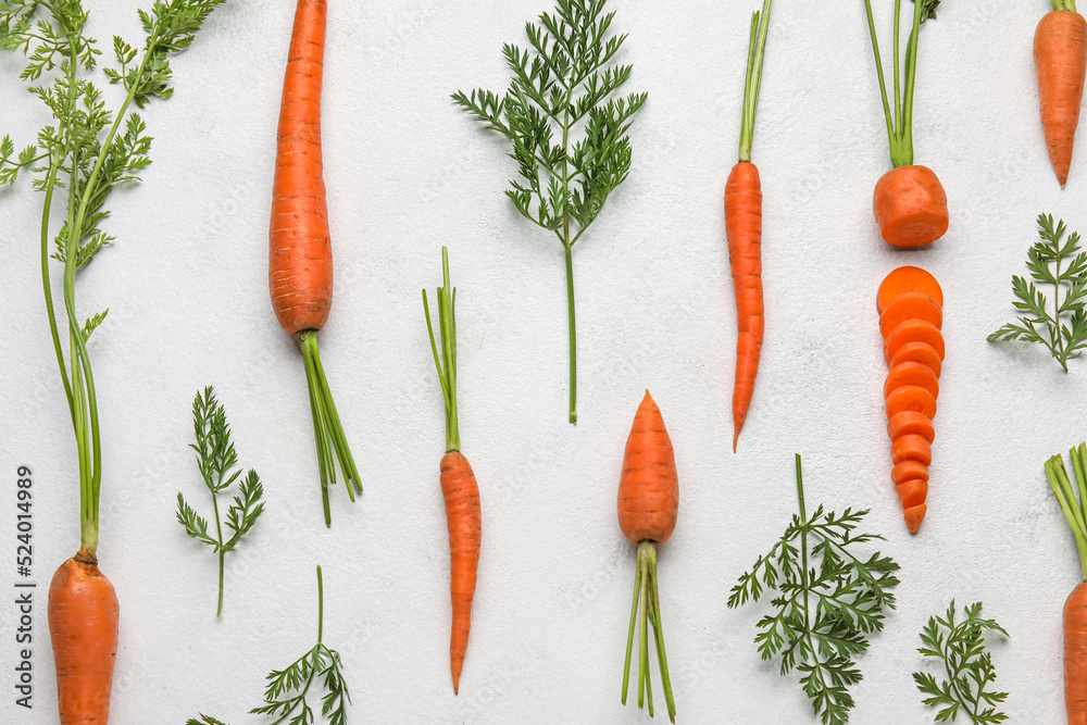 Composition with fresh carrots on light background