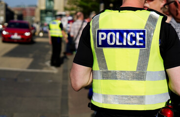 Police officer on duty on a city centre street during special event. 