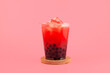 Watermelon boba drink or fruits bubble tea in disposable plastic take away cup. Refreshing  cocktail on pink background. Summer iced drink
