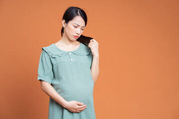 Wall Mural - Photo of Asian pregnant woman on background