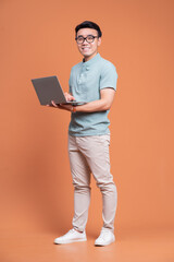 Sticker - Full length image of young Asian man standing on backgound