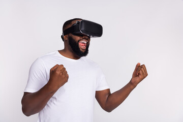 Photo of excited lucky man wear casual t-shirt winning 3d game empty space isolated white color background