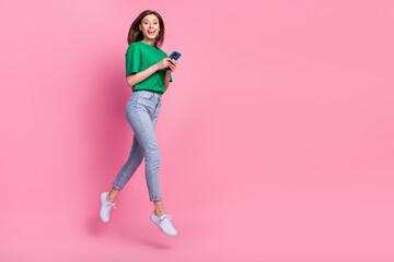 Wall Mural - full length portrait of excited energetic person jump hold telephone empty space isolated on pink co