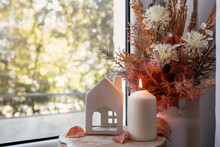 Sweet Home. Still Life Details In Home On A Wooden Window. Autumn Decor On A Window, Dried Flowers, Candle And Toy House