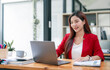 © NAMPIX - Portrait of Successful Young Businesswoman Sitting at Her Desk Working on Laptop Computer in Office.