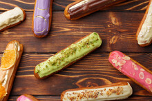 Assortment Of Sweet And Colorful Eclairs On Wooden Background