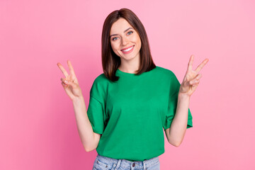 Sticker - Photo portrait of pretty young woman show double v-sign hello toothy smile dressed trendy green clothes isolated on pink color background