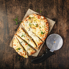 Wall Mural - Roman-style pizzas with cheese. Roman square pizza or Pinsa on a thick dough, Italian Cuisine