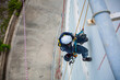 © chitsanupong - Top view male worker inspection wearing safety first harness rope safety line working at a high place on tank roof spherical