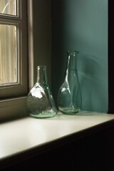 Wall Mural - Vertical closeup shot of blue empty bottles on the windowsill